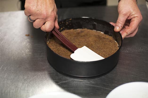 Chocolate Hazelnut Cheesecake Step 2 - Compact Biscuit Base with Spatula 