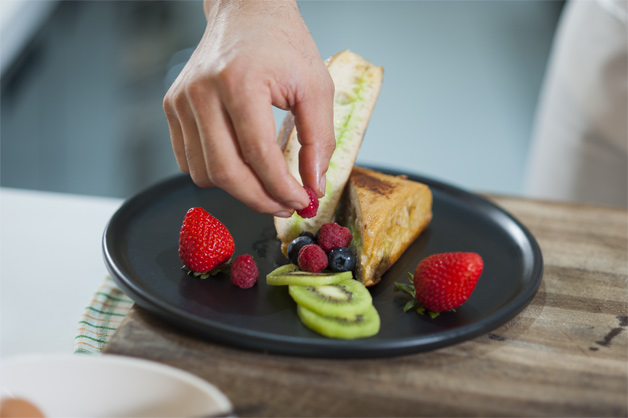 Adding berries to the French toast