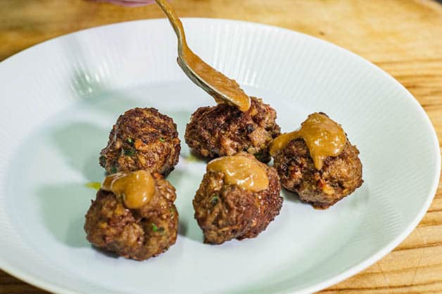 Drizzling mayonnaise on meatballs