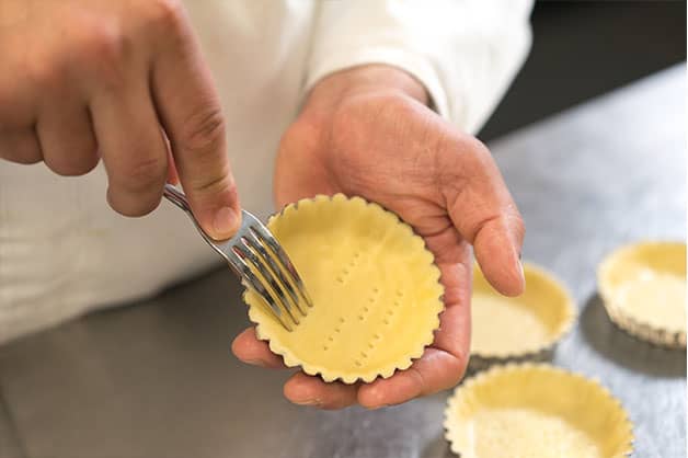 Using a fork to make holes in pastry