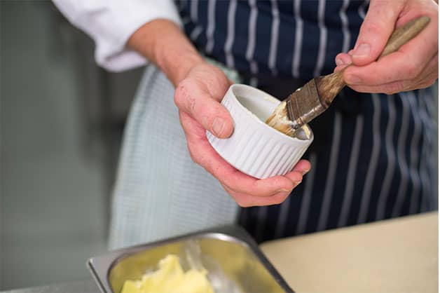 Lining the baking tins with butter