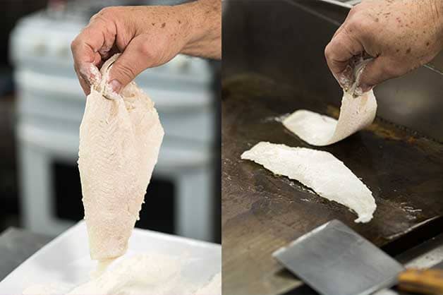Chef coating the fish in flour then grilling it