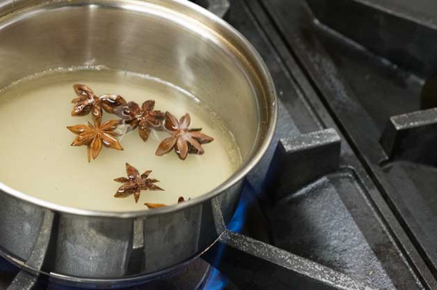 A chef is seen mixing in the star anise