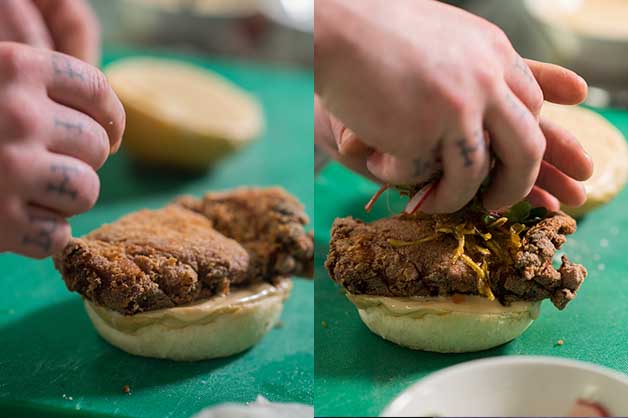 The chef adds the chicken on top of the milk bun in the photo