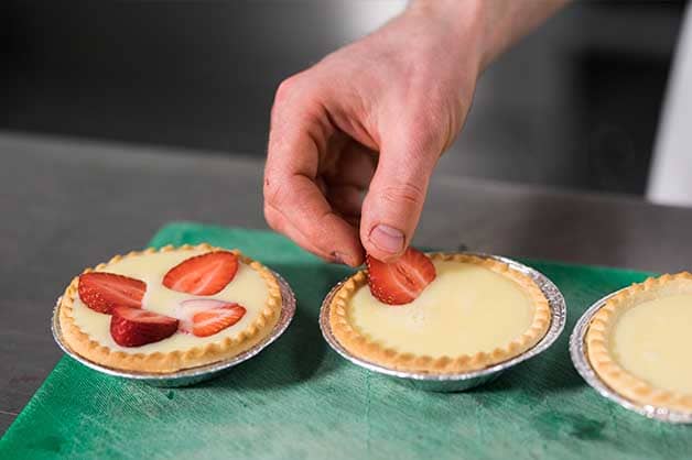 Chef placing the strawberries into the custard mix