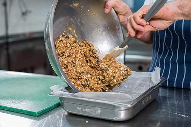 The chef is pictured placing the mixture in a baking dish