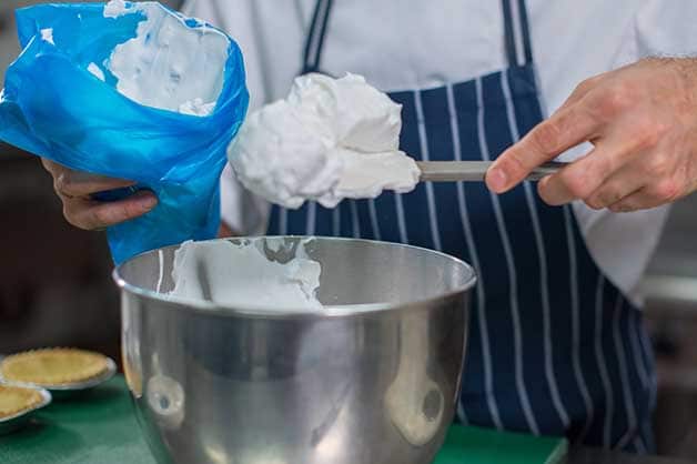 The chef beats the meringue until it is thick