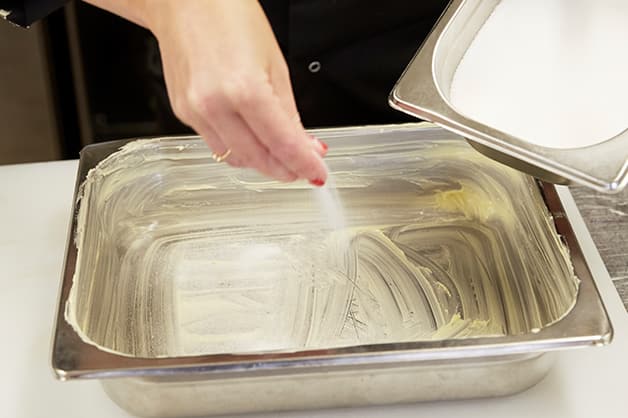 Here the chef is picture sprinkling sugar over the top of the butter