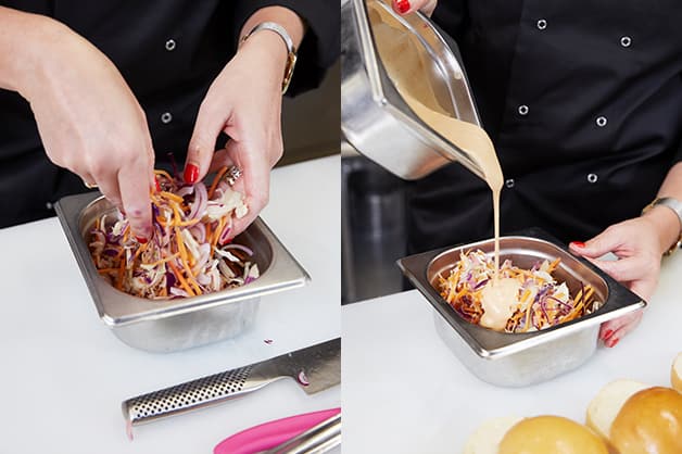 The chef is seen pouring the dressing over the salad mix