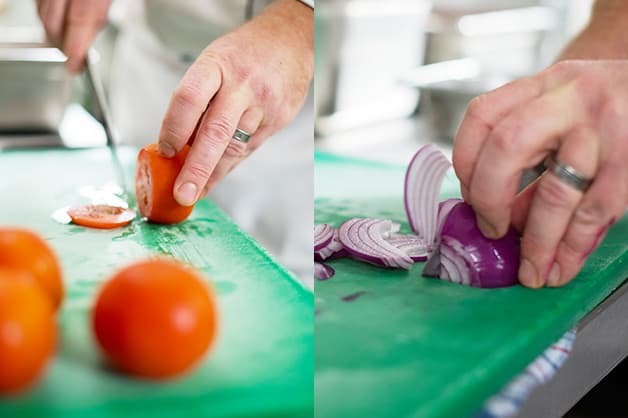 Here, the chef is seen slicing the tomatoes and onions