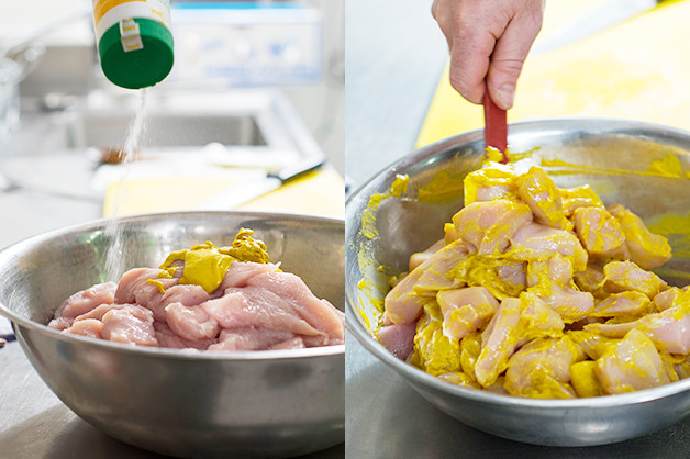 The chef is seen dressing the chicken with mustard