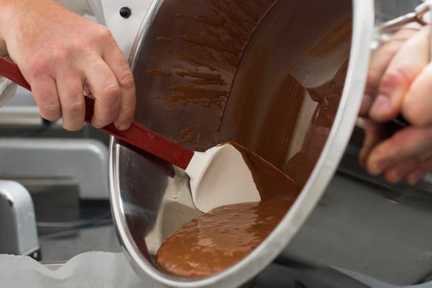 The chef is seen pouring the cake batter into the tray