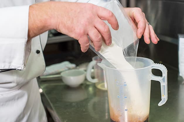 The chef is seen combining creme whip premix and mousse powder