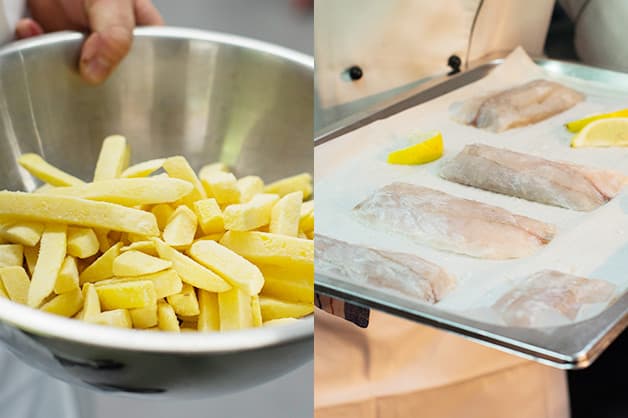 The chef places the tray of barramundi and chips in the oven