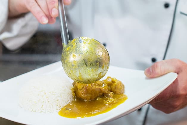 The chef is seen serving the myanmar pork pot with basmati rice