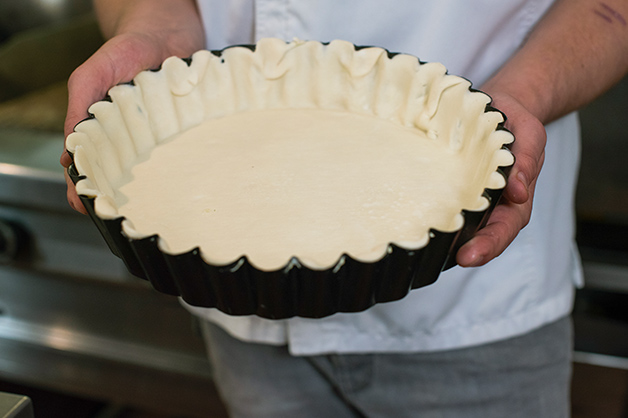 The chef is then pictured cutting off the pastry excess.