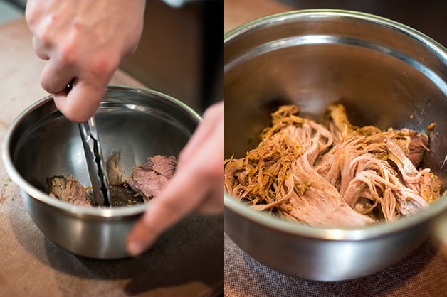 The chef is pictured pulling the pork apart 
