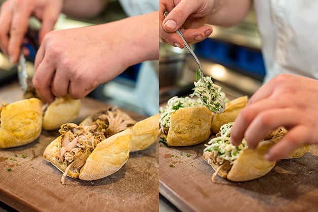The chef is seen adding the pork and salad to the rolls
