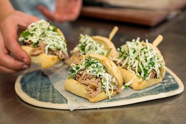 The chef is seen serving the pulled pork rolls