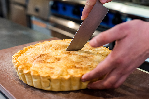 The chef is seen slicing the apple pie