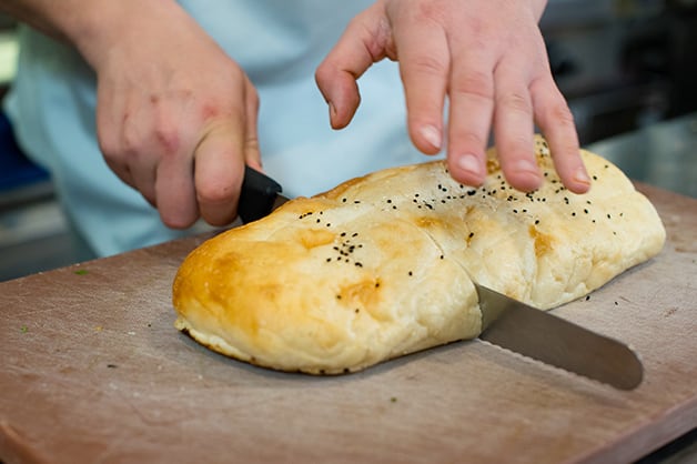 The chef is pictured slicing the QBA Turkish Bread