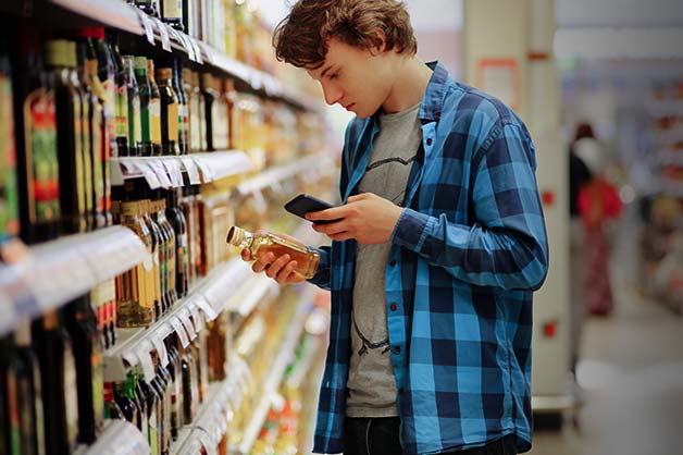 The photo shows a male looking at ingredients in a food product