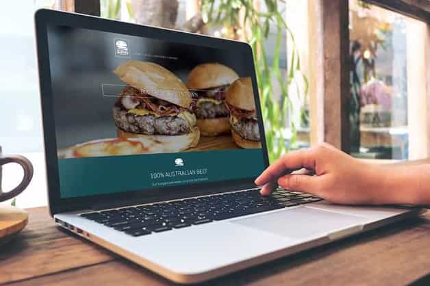 An image of a male creating a website on a laptop