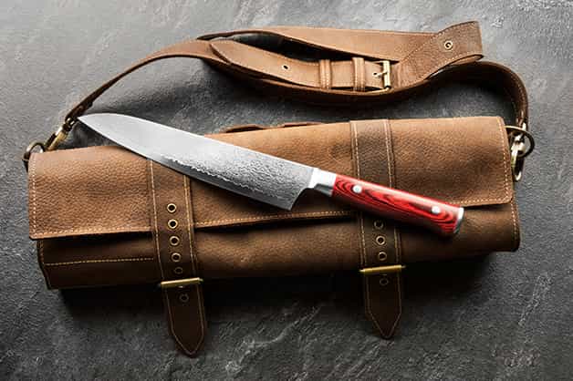 The image is of a knife being stored in a leather bag
