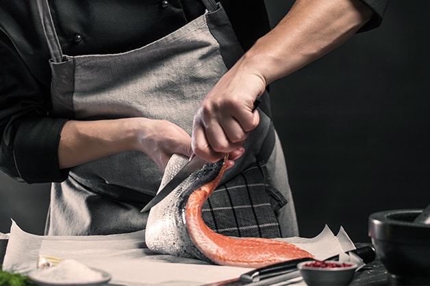 Photo of a chef filleting a fish using a filleting knife