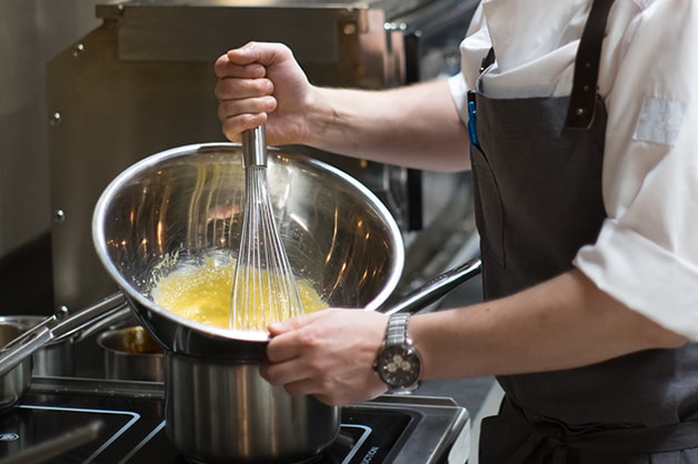 Chef whisking eggs in a bowl