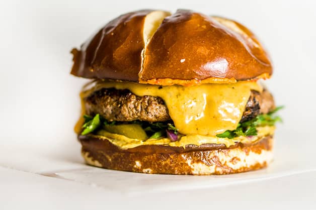Photo shows a burger with melted cheese