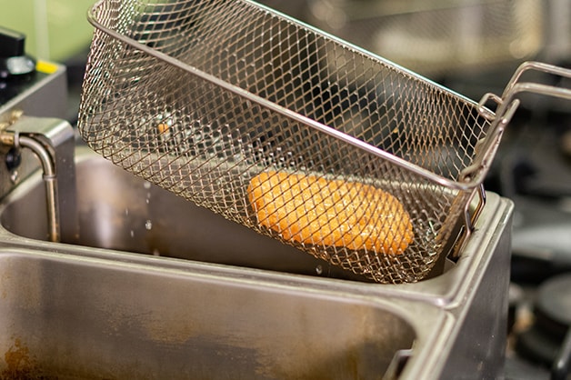 Image shows the hash brown being taken out of the deep fryer