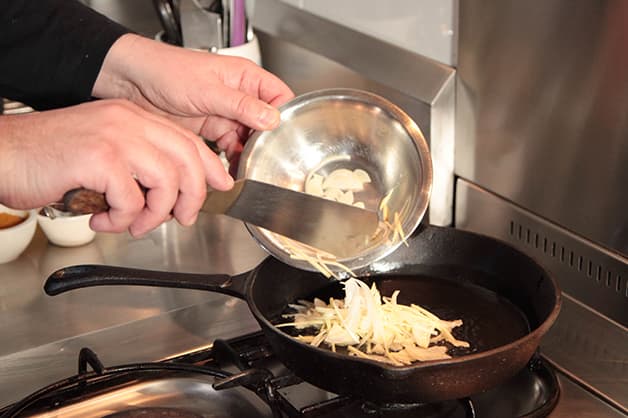 Image shows chef frying the fresh produce