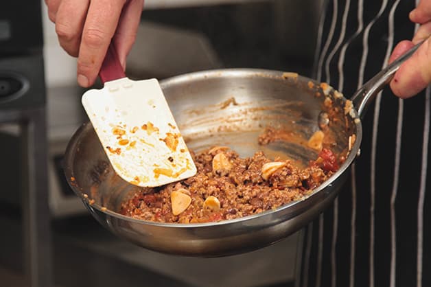 Chef is seen adding the tomato and spices to the mince
