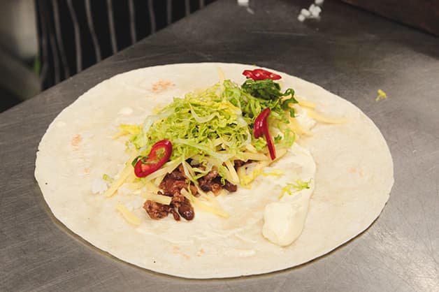 Image of the chef adding the filling for the wrap