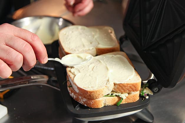 Chef puts the sandwich in the jaffle machine