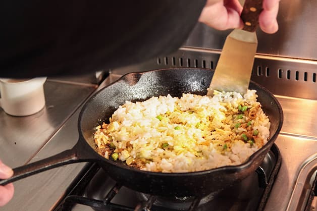 Chef is pictured adding the rice to the pan