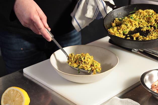 Chef is seen adding the rice mixture to the bowl