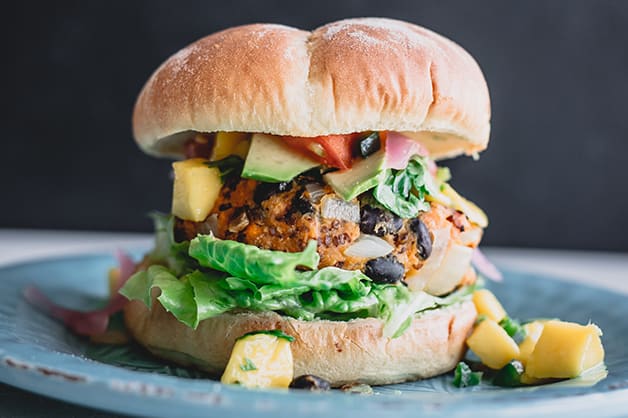 Image is of a plant-based burger with avocado
