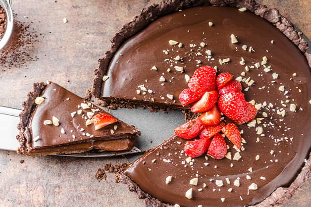 Image is of a chocolate tart with strawberries