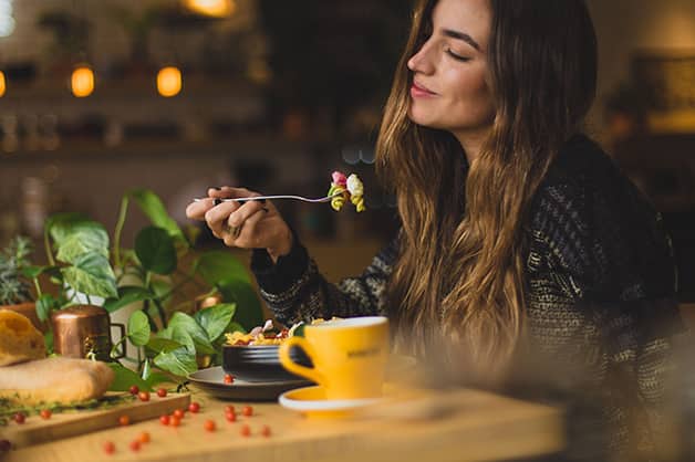 Lady sitting at a table eating on her own at a restaurant