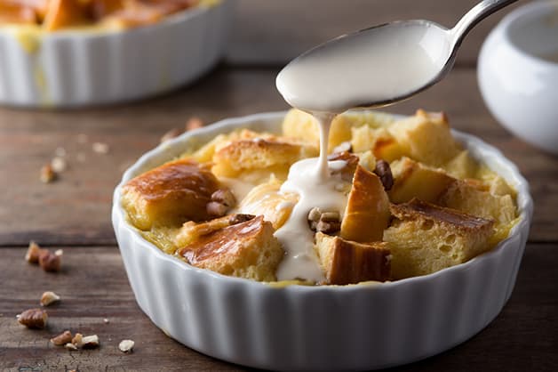 Bread pudding with icing being poured is pictured
