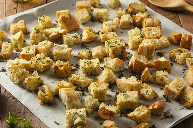 Croutons layed on a tray and coated with olive oil