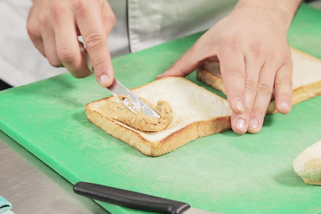 Spreading peanut butter on the Wonder White Bread