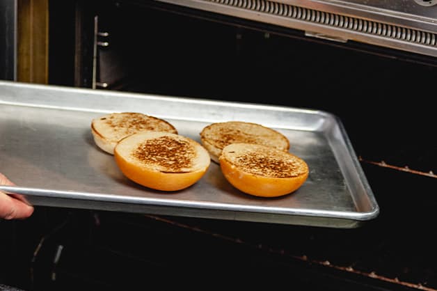 Pulling burger buns out of the oven 