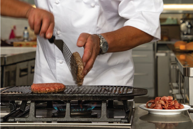 Chef grilling burger patties 