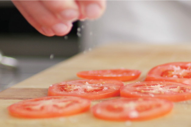 Chef salting tomatoes 