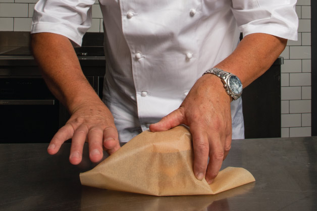 A chef wrapping a burger in paper