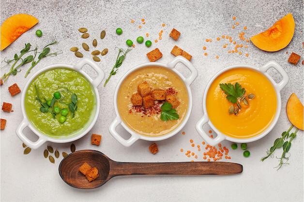three bowls of soup on a table