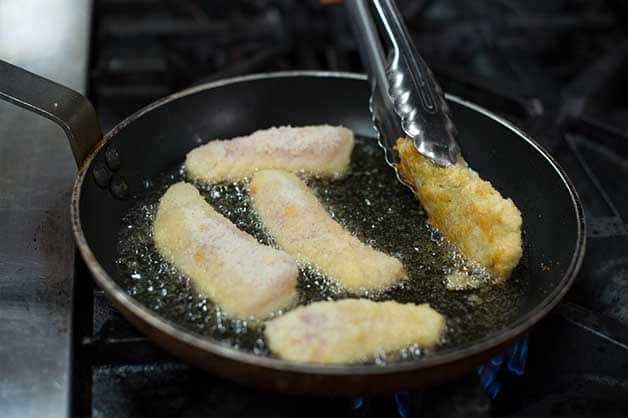 Then the chef drains the oil from the fillets by placing them on a paper towel